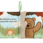 The Jellycat Bartholomew Bear Loves You Book is a soft fabric children's book. It features Bartholomew Bear playing hide-and-seek, with tactile fabrics for little hands to explore. The background showcases trees and flowers, accompanied by the text: "Bartholomew loves playing hide-and-seek.