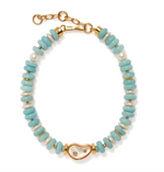 The Lizzie Fortunato Goddess Collar by Lizzie Fortunato is a beaded necklace showcasing turquoise-colored beads, gold accents, freshwater cultured pearls, a central gold plate with a heart shape, and an adjustable clasp.