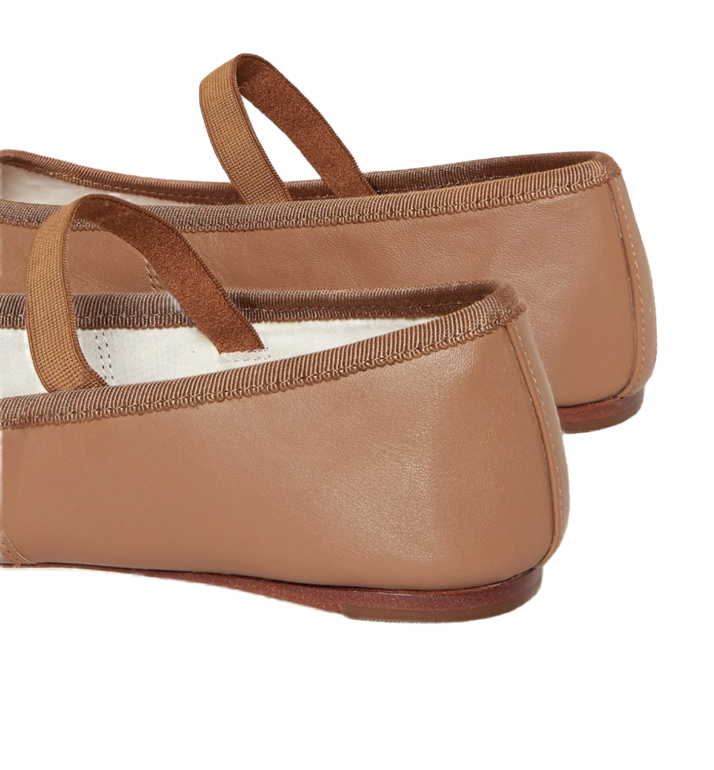 Close-up of the back of a pair of Loeffler Randall Leonie Soft Ballet Flats, made from tan calf leather with brown elastic straps and brown trim, positioned on a white background.