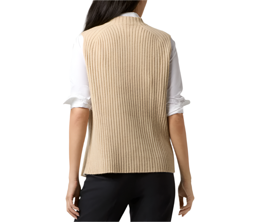 Back view of a woman wearing the Ann Mashburn Sleeveless Funnel-Neck Sweater in beige over a white long-sleeve shirt and dark pants.