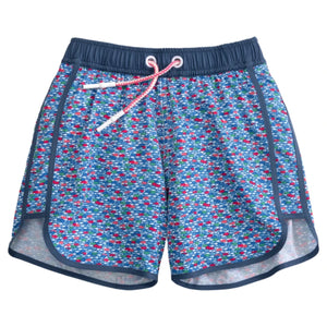 Johnnie-O Boys' Full Elastic Jr. Surf Red Fin Blue Fin Swim Shorts feature a blue, red, and white geometric pattern with navy trim and a white and red drawstring at the elastic waistband.
