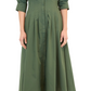 A person wearing the Simkhai Signature Jazz Dress, a long-sleeve collared midi dress with elegant pintuck detailing in green, stands with arms relaxed while donning black strappy sandals.