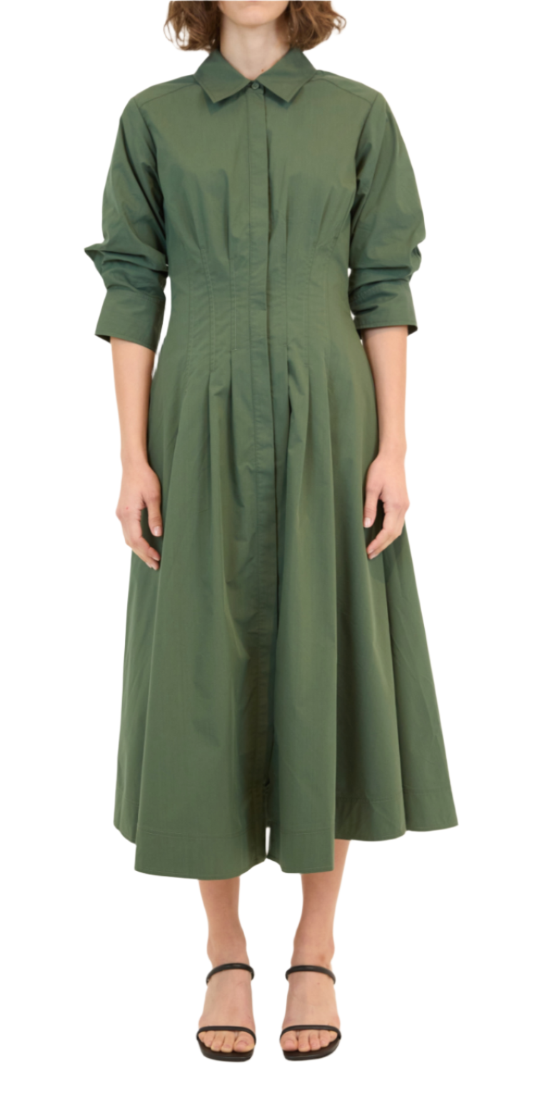 A person wearing the Simkhai Signature Jazz Dress, a long-sleeve collared midi dress with elegant pintuck detailing in green, stands with arms relaxed while donning black strappy sandals.