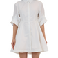 A person wearing the Simkhai Jazzie Mini Dress, a white knee-length button-up dress crafted from crisp poplin with rolled-up sleeves.