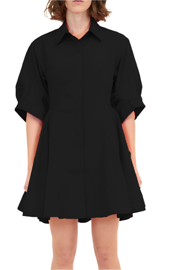 A person stands against a plain white background, showcasing the Simkhai Jazzie Mini Dress in sleek black. Made from soft, breathable cotton, this knee-length dress features short sleeves and a collar, seamlessly blending elegance with comfort for any occasion.