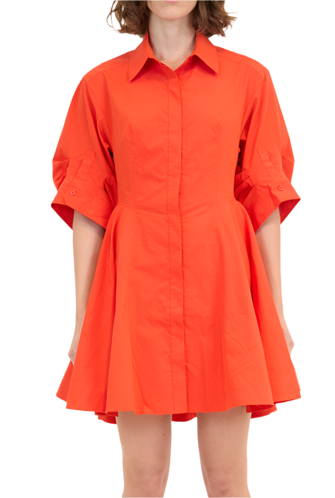 A person wearing the Simkhai Jazzie Mini Dress, characterized by its poplin fabric, vibrant orange color, collared neckline, short sleeves, and flared skirt design.