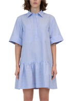 A person dressed in the Simkhai Cris Shirt Dress, featuring a blue and white striped design with a button-down front, traditional collar, loose fit, and ruffled hem.