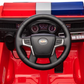Close-up view of the Freddo Fire Truck dashboard with steering wheel, control buttons, speedometer dials, and a red and blue light bar—perfect interactive features for any kids hero toy collection.