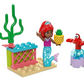 A LEGO® Disney Ariel's Music Stage set from Legos - Toyhouse features a mermaid figure that resembles Disney’s Ariel, holding a pineapple next to a red crab figure and a piece of coral. The enchanting scene is completed with a small structure crafted from colorful building blocks.