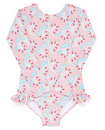 The Minnow Girls' Rashguard One Piece is a long-sleeve pink swimsuit that showcases a charming floral and dolphin print. It features sun-safe fabric and ruffled details at the hips for an added touch of style.