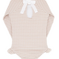 The Minnow Girls' Rashguard One Piece is a beige and white gingham long-sleeve baby bodysuit, highlighted by a charming back bow tie made with grosgrain ribbon and adorned with ruffled leg openings.