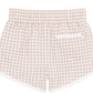 The Minnow Boy's Boardie shorts by Minnow provide boys with style, comfort, and mobility, featuring an elastic waistband and a back pocket in a beige and white gingham checkered pattern.