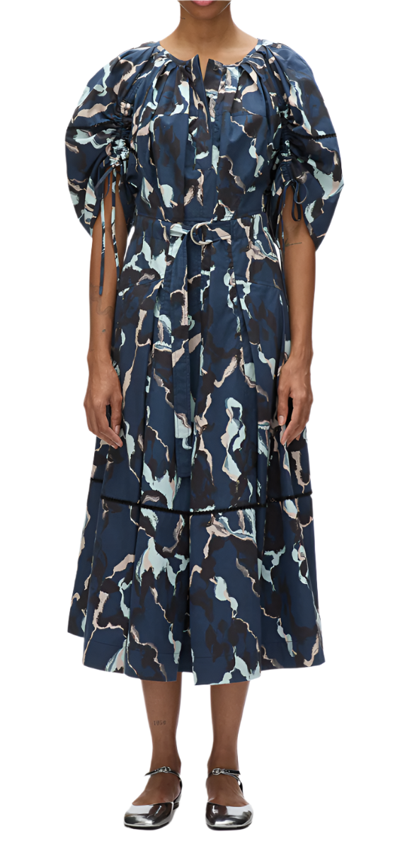 A person wearing the 3.1 Phillip Lim Abstract Vines Belted Dress in blue and black, featuring puff sleeves, a tiered skirt, and a belted waist.