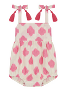 The Mer St Barth Zoe Romper by Mer is a charming pink and white patterned baby romper with shoulder straps and tassel bows, perfect as a playful summer staple.