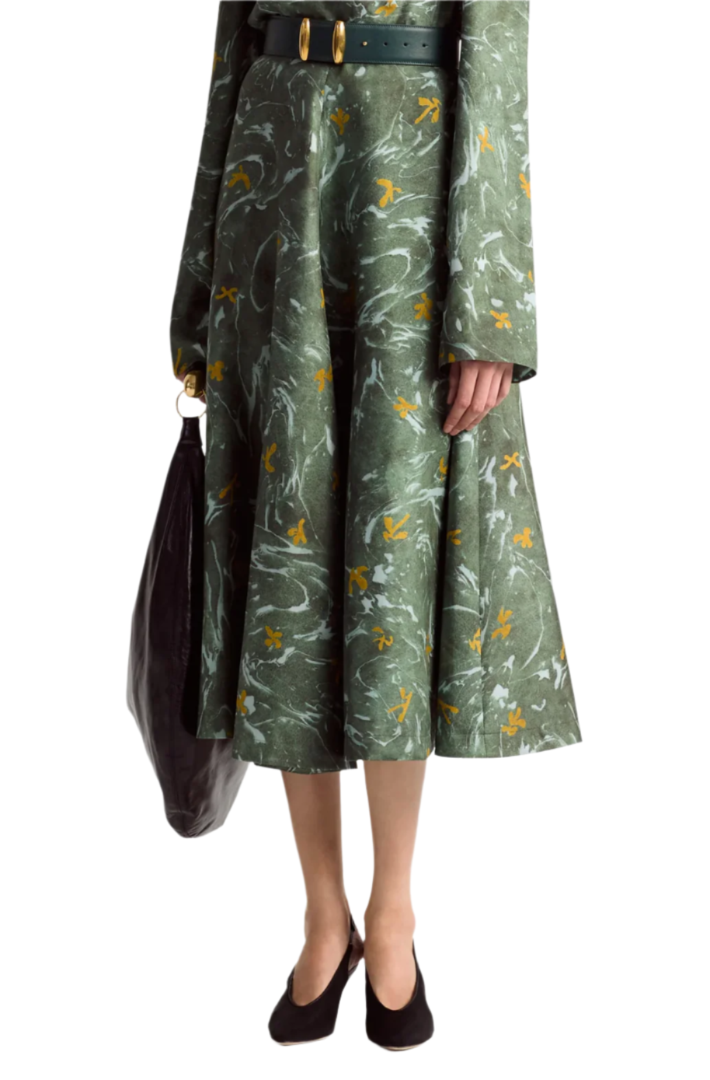 A person is wearing a long-sleeve green marbled floral print midi dress and holding a black bag from Altuzarra's Varda Skirt collection.