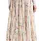 A person is stylishly showcasing the chic Altuzarra Sif Skirt, a pleated mid-length floral design, paired gracefully with a white long-sleeve top and complemented by beige heels.