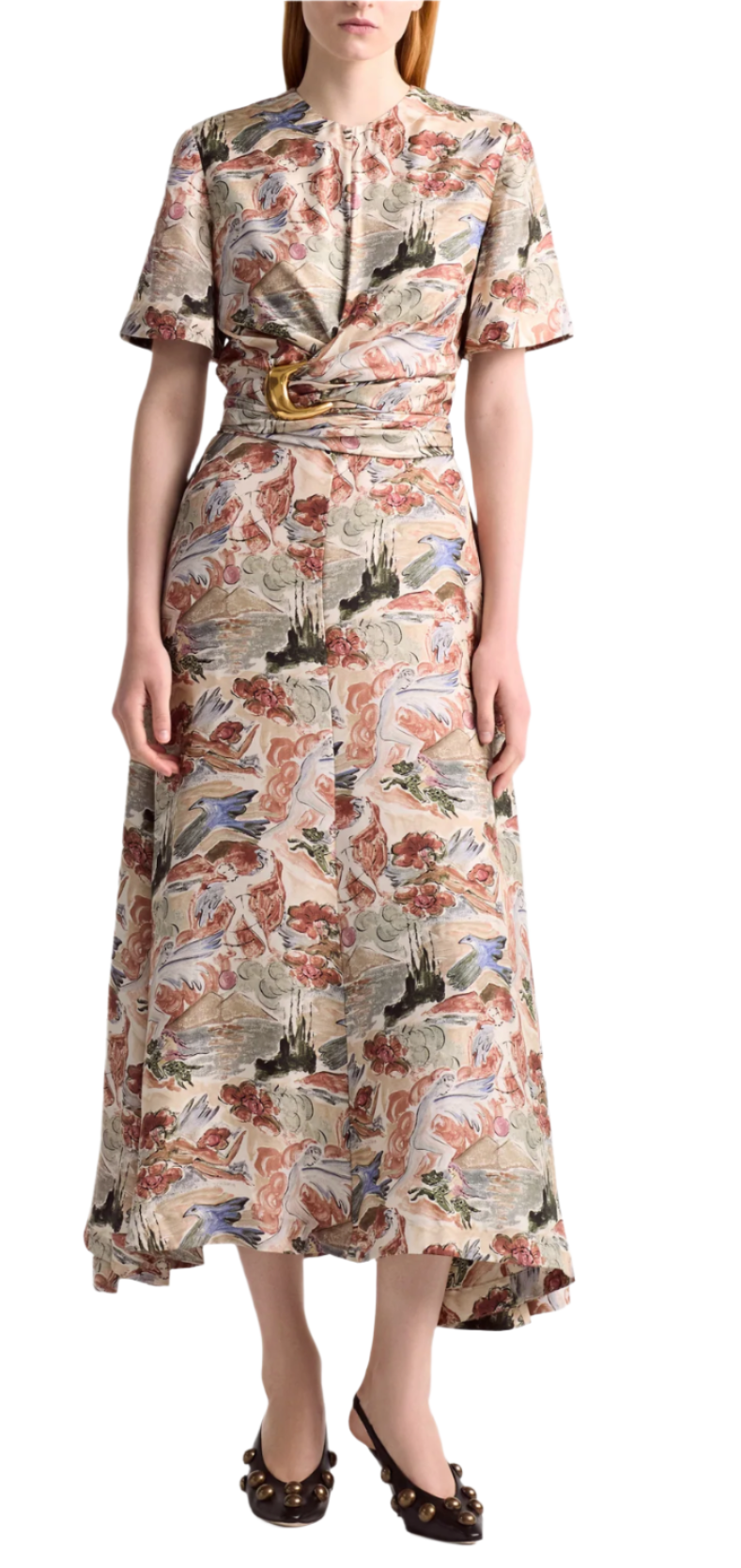 A person wearing the Altuzarra Honey Dress—a patterned, short-sleeve, ankle-length silk dress with a draped waist—paired with black heeled shoes featuring an oversized buckle.