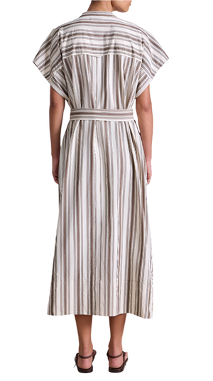A woman, seen from behind, wears the Apiece Apart Isola Caftan Dress—a calf-length, short-sleeve style with vertical brown and white stripes and a matching belt—teamed with brown sandals.