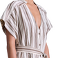 A person wears the Apiece Apart Isola Caftan Dress, featuring short sleeves, stripes, a V-neck, and a matching waist tie, styled with sandals.