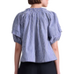 A person seen from the back wears the Apiece Apart Caminitas Puff Sleeve Top, a blue and white classic striped blouse with gathered neckline—ideal for effortless summer style.