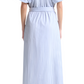 A woman is shown from the back wearing the Altuzarra Paulina Banker Stripe Dress—an ankle-length cotton poplin shirt dress with pleats, short sleeves, and a belt—paired with nude heels.