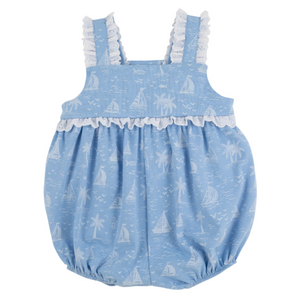 The Beaufort Bonnet Company’s Baby Girls' Babs Bubble is a light blue cotton romper with Worth Ave White ruffle strap trim and a nautical sailboats, palm trees, and fish print.