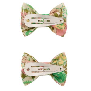 Two Bonpoint Miniclic hair clips made with pale pink Liberty fabric, each featuring a floral print bow and a metal snap clip, displayed on a white background.