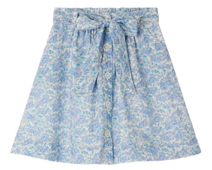 The Bonpoint Girls' Esterina Buttoned Skirt, made with Liberty fabric, features a light blue floral print, front button closure, and matching bow waist. Shown on a white background.