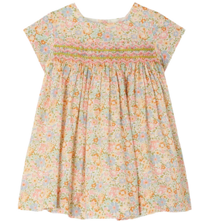 The Bonpoint Baby Girls' and Girls' Maruska Smocked Dress, made with Liberty fabric, features multicolored floral print, hand-embroidered smocking on the chest, short sleeves, and a loose silhouette.