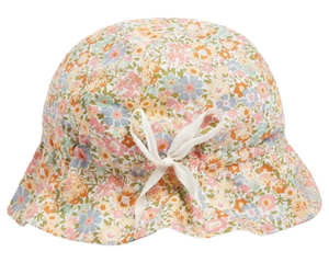 The Bonpoint Grigri Hat with Ties features pastel multicolored flowers in Liberty fabric, a bucket-style design for babies, and is finished with a white front bow.