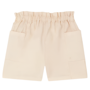 Bonpoint Girls' Evera Shorts in Denim shown on a white background, in light beige, with lightweight fabric, an elastic ruffled waistband, and two large front pockets.