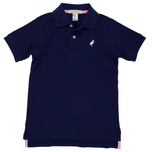 The Beaufort Bonnet Company Baby Boys' and Boys' Prim & Proper Polo is a navy blue short-sleeve collared shirt featuring two buttons and a small white bird logo on the left chest.
