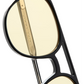 Close-up of The Lars by Jimmy Fairly: black cellulose acetate glasses with yellow-tinted lenses, detailed gold metal temple arm, and a cutout design on the frame.