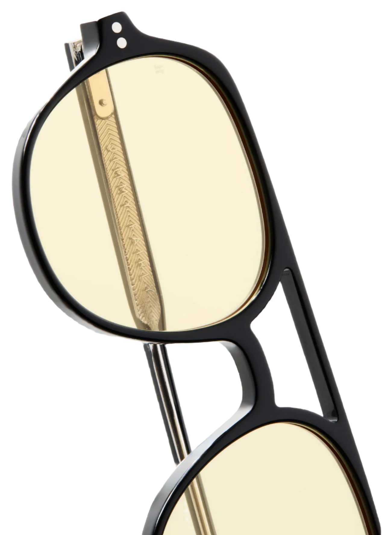 Close-up of The Lars by Jimmy Fairly: black cellulose acetate glasses with yellow-tinted lenses, detailed gold metal temple arm, and a cutout design on the frame.
