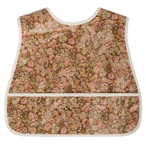 The Bonpoint Jlip Adjustable Bib, crafted from Liberty Fabrics with beige trim and a front pocket, is shown flat on a white background.