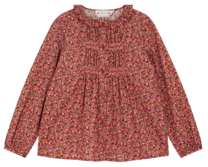The Bonpoint Girls' Gentille Smocked and Embroidered Blouse is crafted from Liberty organic cotton with floral patterns, a ruffled neckline, and gathered front detailing in pink and red tones.