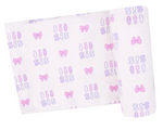 The Angel Dear Swaddle Blanket is a white viscose from bamboo swaddle with a repeating “sis” pattern in purple and pink, plus pink and purple bows and ovals.