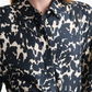 A person wearing the Altuzarra Chika Top—a relaxed, black and white abstract animal print silk shirt with a concealed button front—paired with a black belt.
