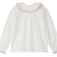 The Bonpoint Girls' Janeke Blouse, crafted from pleated organic cotton, features an embroidered collar and is shown from the back.