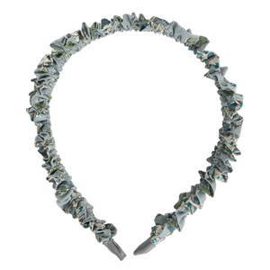 The Bonpoint Jovie Headband in Blue Organic Cotton Liberty Fabric features a blue and green floral print with a ruched, gathered design.