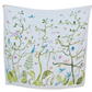 The Timo & Violet Shawl Blanket is a white organic cotton baby accessory with a vibrant, hand-painted pattern of leafy vines, birds, butterflies, and a peacock—perfect for brightening any nursery.