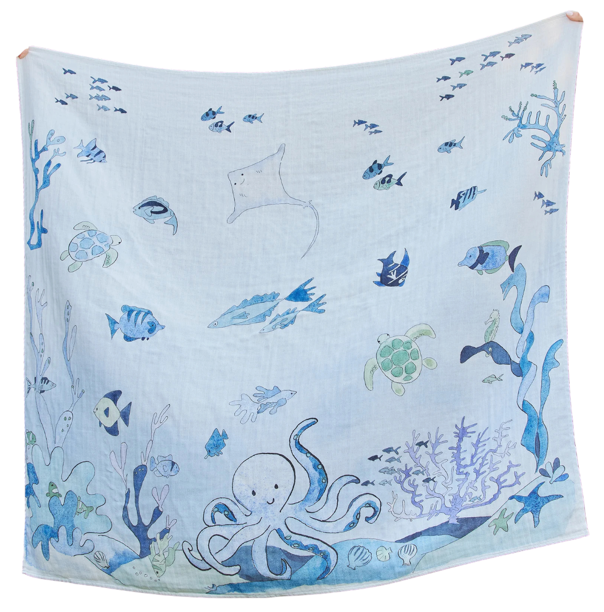The Timo & Violet Shawl Blanket features light blue organic cotton with playful sea creatures—fish, octopus, turtles, stingray, and coral—creating a gentle underwater scene. Ideal as a baby accessory or shawl blanket for cozy comfort.