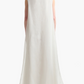A person with long hair stands with their back to the camera, wearing Altuzarra's floor-length, sleeveless white silk Jools Dress.