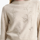 A woman wears the Altuzarra Paulie Sweater, crafted from cream virgin wool with embroidered floral patterns, beaded embellishments, and ribbed collar and hem.