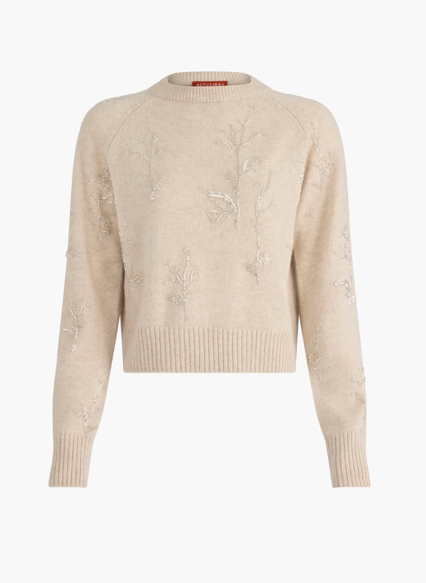 The Altuzarra Paulie Sweater is a beige long-sleeve knit crafted from virgin wool, detailed with embroidered floral designs, beaded embellishments, and finished with ribbed cuffs and hem.