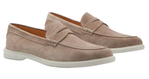 The Peter Millar Excursionist Penny Loafer is a light brown suede shoe with a water-resistant finish, white rubber soles, penny strap detail, and a lightweight EVA outsole for all-day comfort.