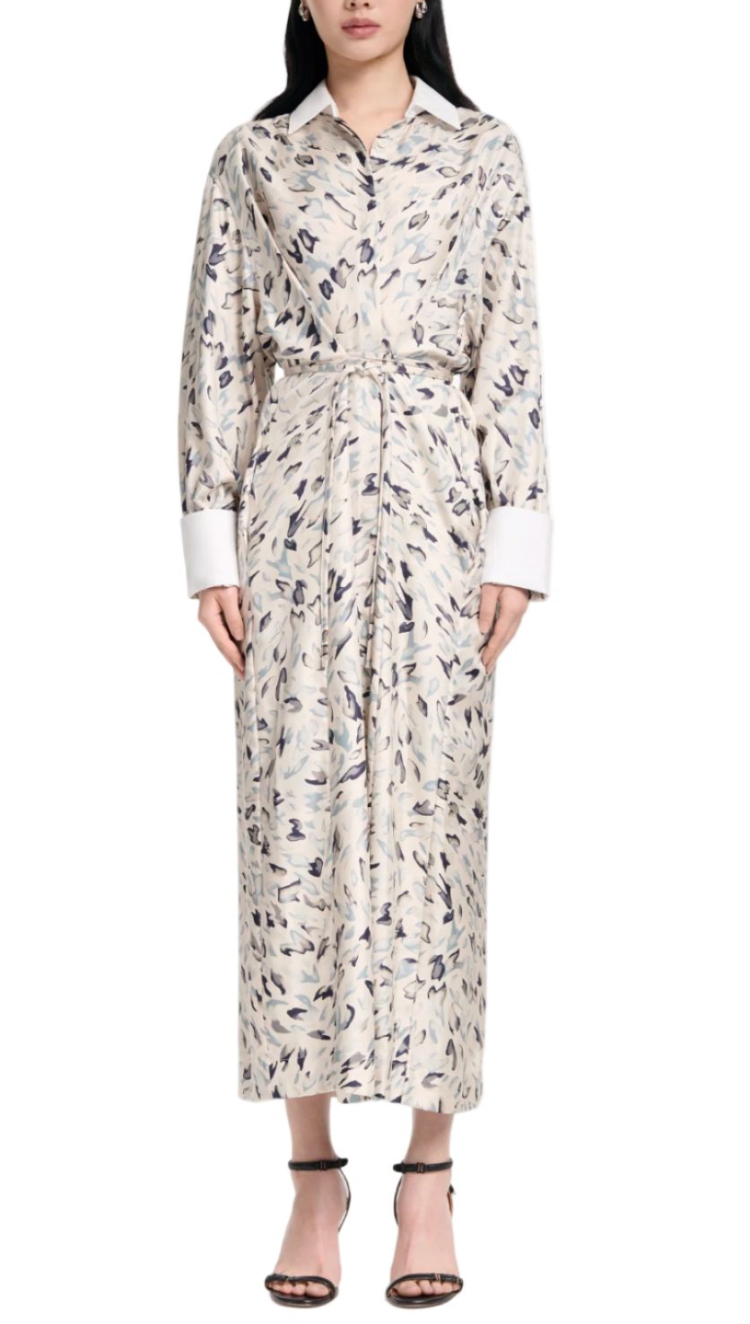 A person wearing the Altuzarra Floyd Dress, featuring an abstract animal pattern in a collared shirt silhouette with a waist tie, paired with black heeled sandals.