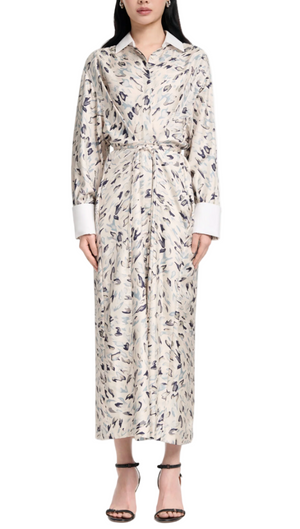 A person wearing the Altuzarra Floyd Dress, featuring an abstract animal pattern in a collared shirt silhouette with a waist tie, paired with black heeled sandals.