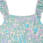Close-up of the Bonpoint Baby Girls' & Girls' Cecilia One Piece Swimsuit, a sleeveless style with ruffled straps and a pastel floral pattern in purple, blue, and green.