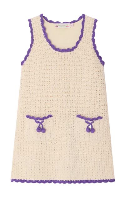 The Bonpoint Girls' Lali Hand-Crocheted Dress is a sleeveless cream summer dress featuring purple scalloped trim and two front pockets with purple bows—handmade for charm and perfect for sunny days.